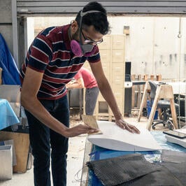 Ani sanding a resin coated foam wing mold in preparation for carbon fiber coating for the Highlander Racing, FSAE car.