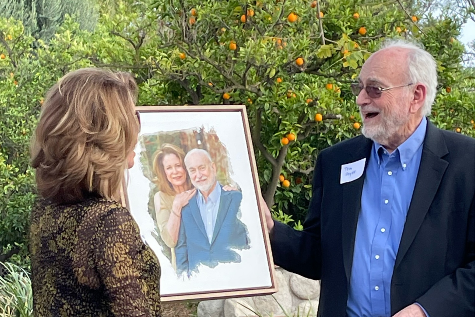 Professor Tom Payne and his wife Valerie are surprised with a portrait on canvas.