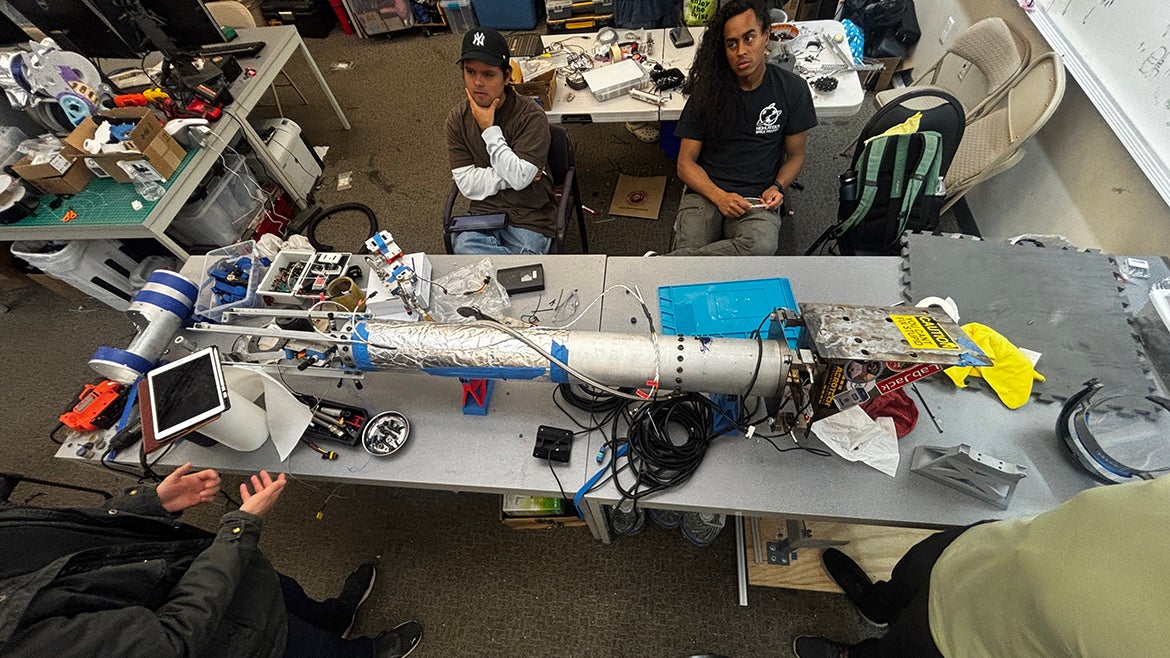 Photo of a UCR Highlander Space Program rocket surrounded by students.