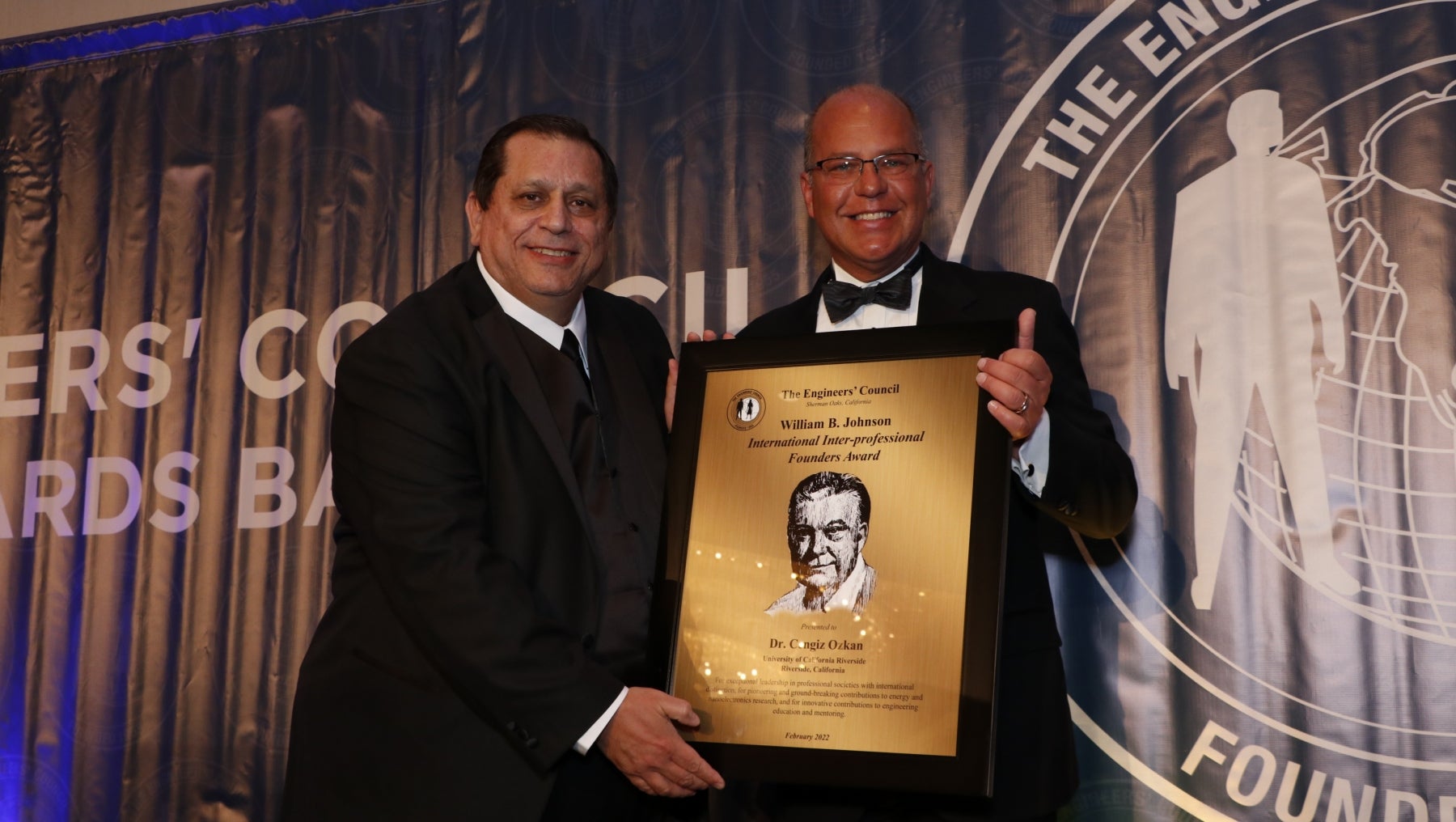 Professor Ozkan holds award plaque and poses with Kenneth Davis 