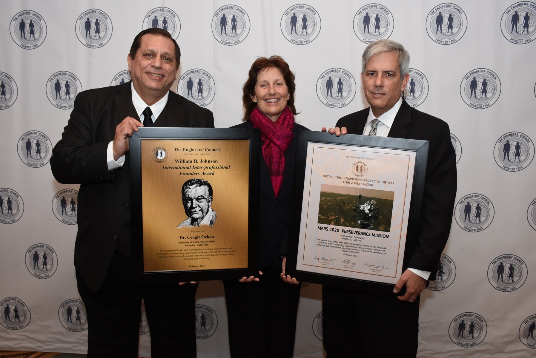 Ozkan holds award plaque and poses with Matt Wallace and third person 