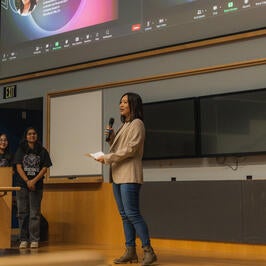 Photo of keynote speaker and BCOE alumni speaking onstage to Rose Hack participants.