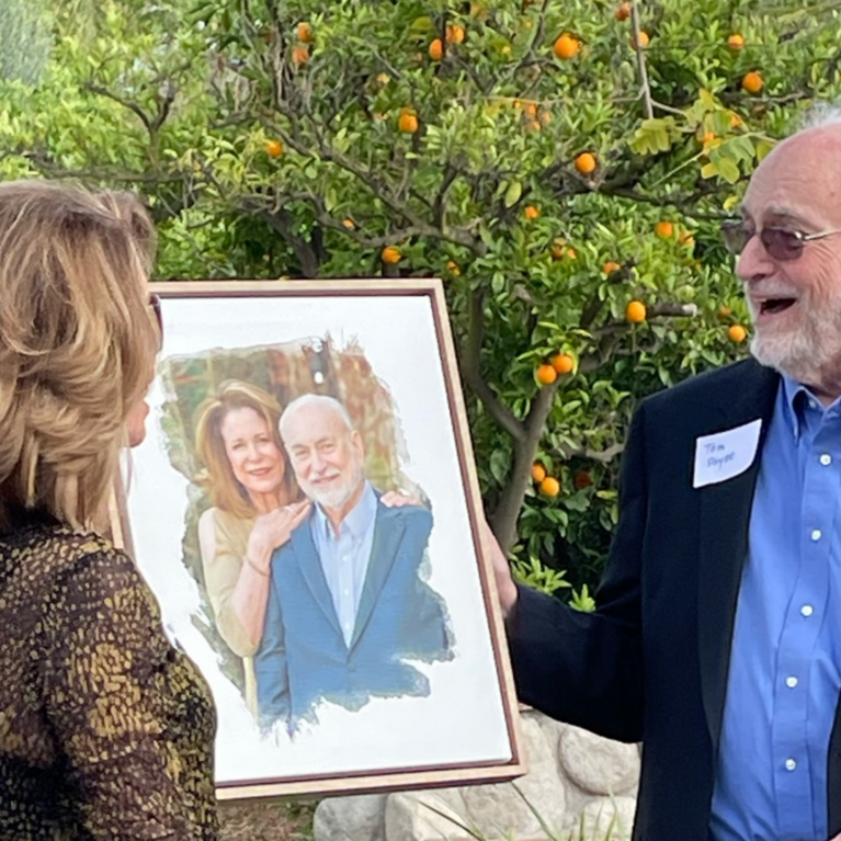 Professor Tom Payne and his wife Valerie are surprised with a portrait on canvas.