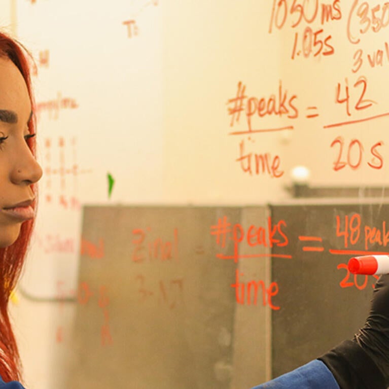 UCR BCOE bioengineering doctoral student Samantha Robinson writing on a dry erase board.