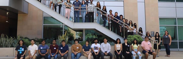 Photo of a group of several dozen data science students posing for a group photo in courtyard
