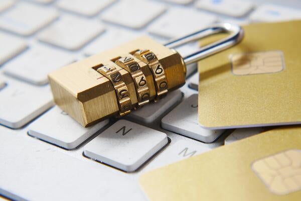Padlock and two credit cards on top of laptop keyboard