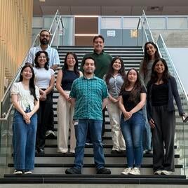 Group of student researchers and faculty posing on stairs 