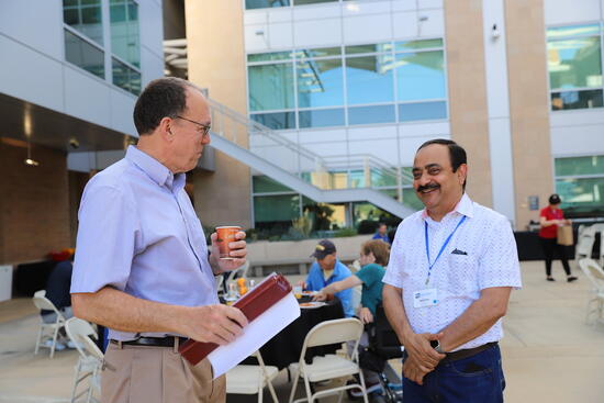 Dean Lynch speaking with a parent on Winston Chung patio